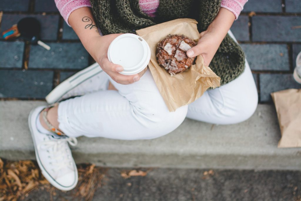 person sitting while holding white tumbler taking a break